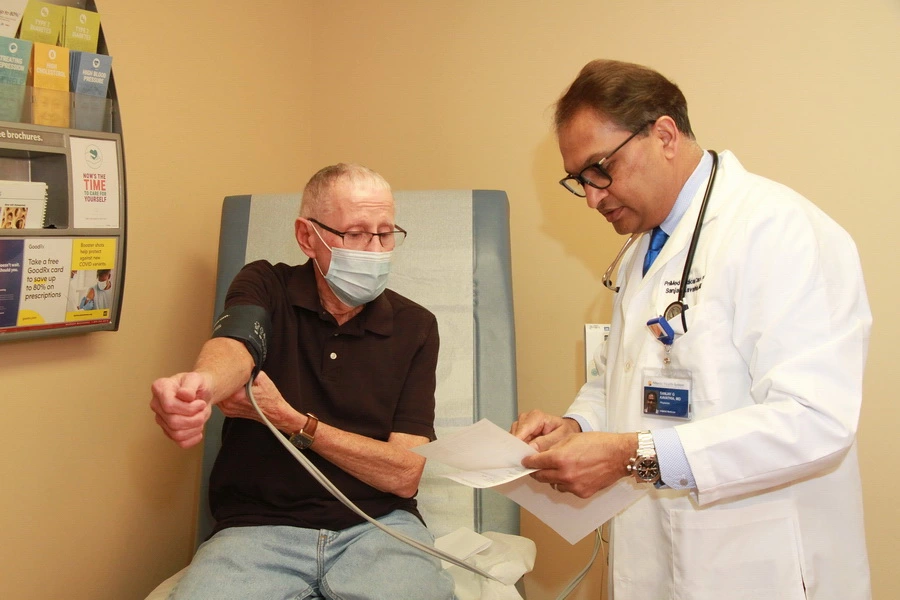 Dr Kavathia helping an elderly patient